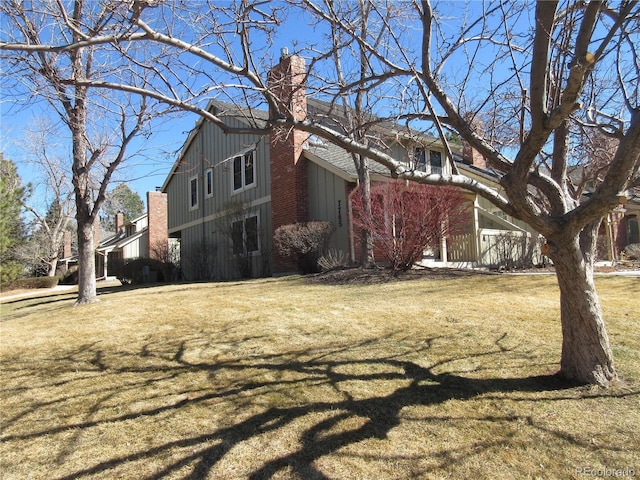 view of side of home featuring a yard and a chimney