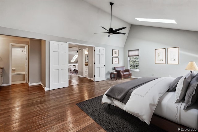 bedroom with hardwood / wood-style floors, baseboards, high vaulted ceiling, a skylight, and connected bathroom