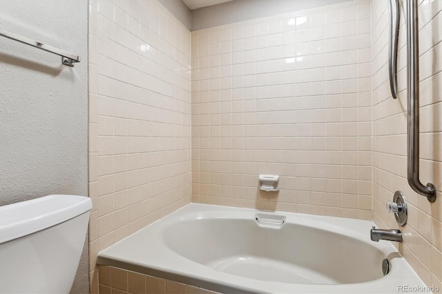 full bathroom with toilet, bathing tub / shower combination, and a textured wall