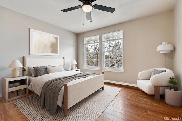 bedroom with a ceiling fan, baseboards, and wood finished floors