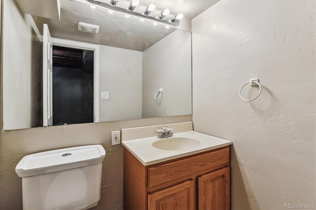 bathroom with toilet and vanity