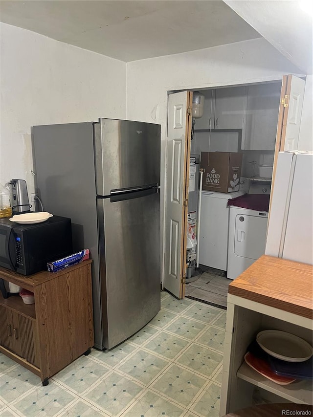 1132 Moline St, Aurora, CO 80010 - kitchen featuring black microwave, separate washer and dryer, light floors, and freestanding refrigerator