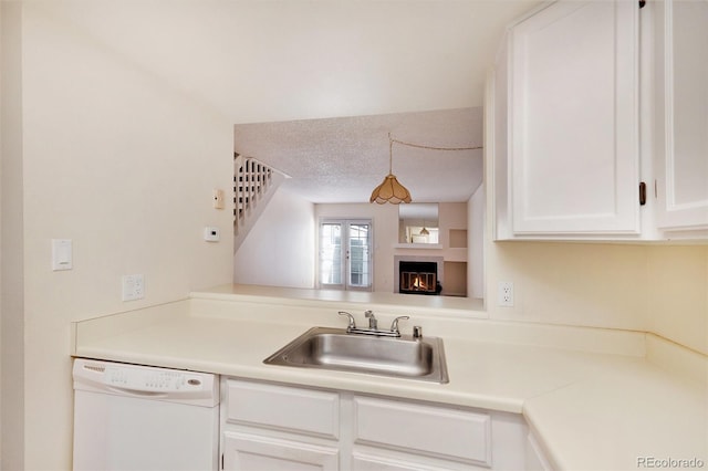 kitchen featuring white cabinetry, sink, white dishwasher, and a textured ceiling