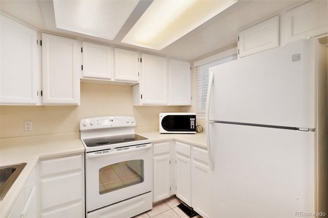 kitchen with white cabinets, light tile patterned floors, white appliances, and sink