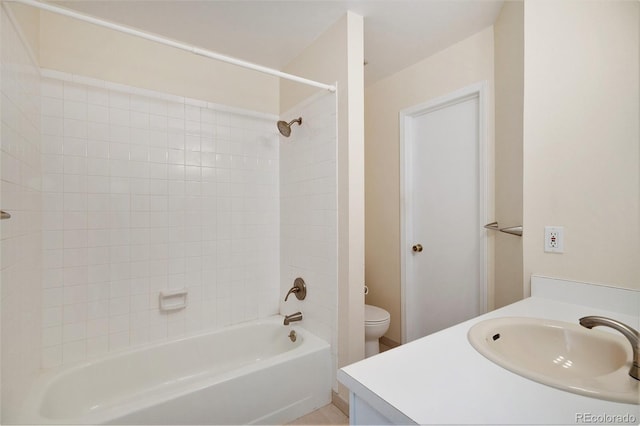 full bathroom with vanity, tiled shower / bath combo, and toilet