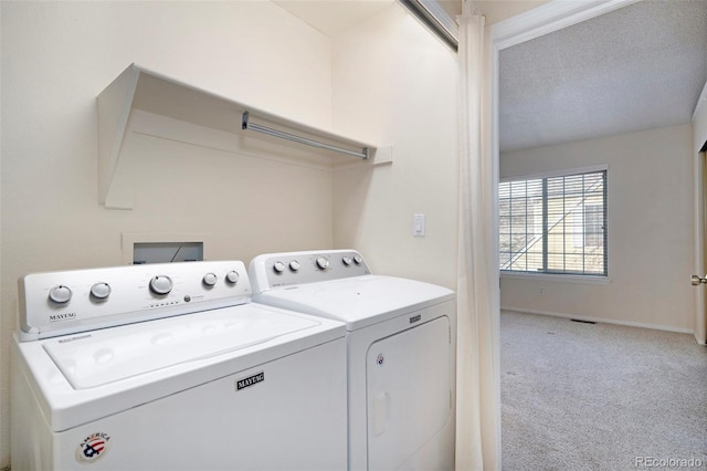 washroom with carpet, washing machine and dryer, and a textured ceiling