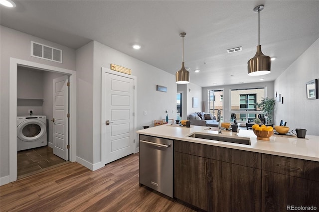 kitchen featuring sink, dishwasher, dark brown cabinets, dark hardwood / wood-style flooring, and washer / clothes dryer