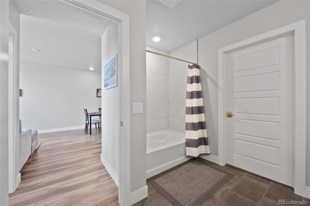 bathroom featuring shower / tub combo with curtain and hardwood / wood-style flooring