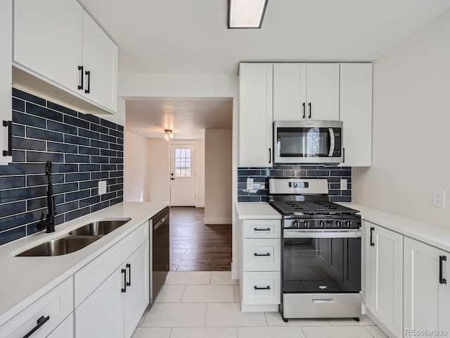 kitchen featuring light wood-type flooring, sink, appliances with stainless steel finishes, and white cabinets