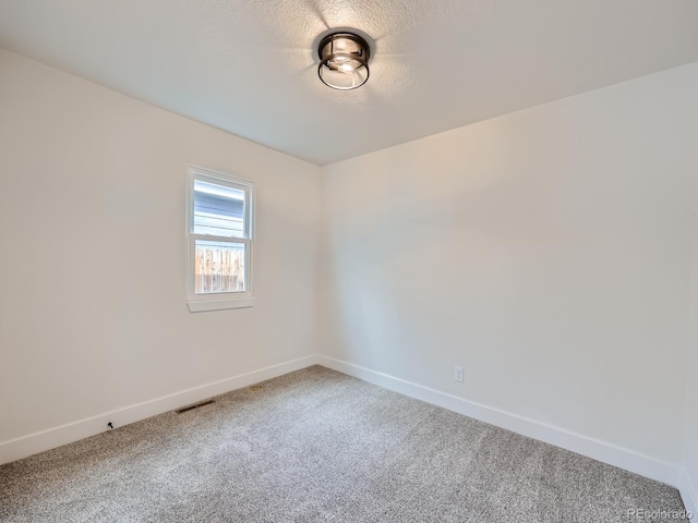 unfurnished room featuring a textured ceiling and carpet flooring