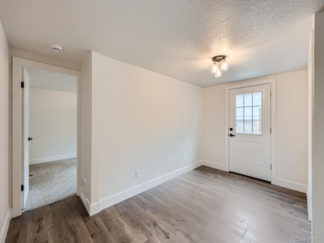 entrance foyer with a textured ceiling and hardwood / wood-style flooring