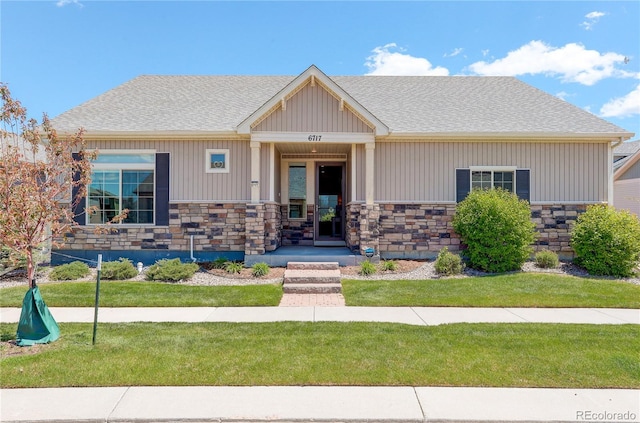 6717 Golden Briar Ln, Colorado Springs, CO 80927 - craftsman-style home featuring stone siding, a front yard, and roof with shingles