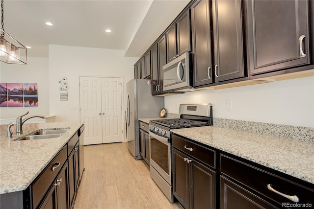 6717 Golden Briar Ln, Colorado Springs, CO 80927 - kitchen with stainless steel appliances, a sink, light wood-style floors, light stone counters, and recessed lighting