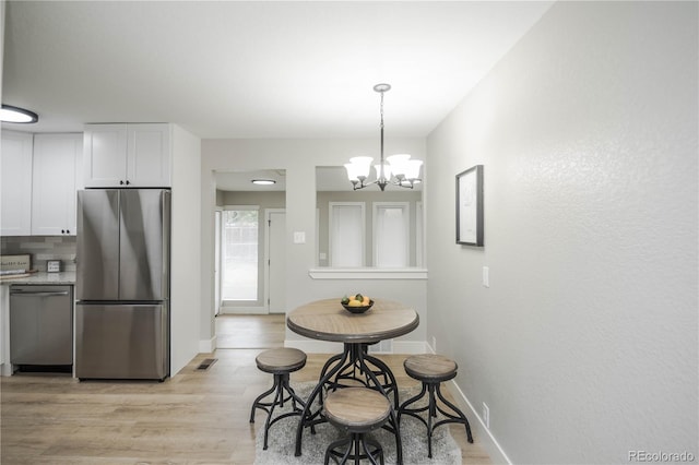 740 Moline St, Aurora, CO 80010 - dining room with a chandelier, light wood-style floors, and baseboards
