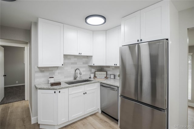 740 Moline St, Aurora, CO 80010 - kitchen featuring appliances with stainless steel finishes, a sink, light wood-style floors, and white cabinets