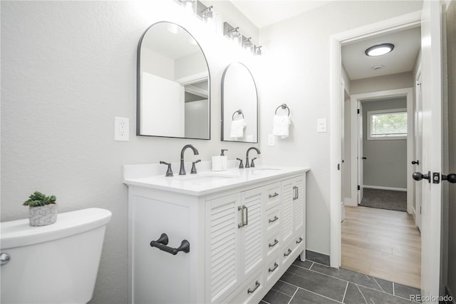 740 Moline St, Aurora, CO 80010 - bathroom featuring toilet, double vanity, baseboards, and tile patterned flooring