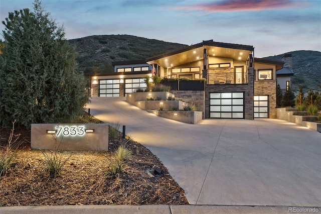 contemporary house with a balcony, a mountain view, and a garage