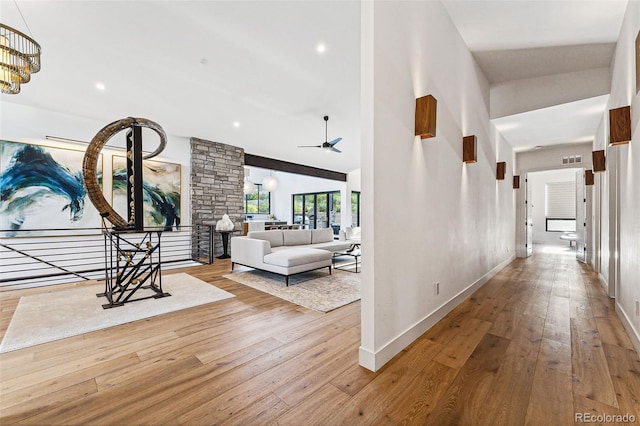 corridor featuring light hardwood / wood-style flooring and high vaulted ceiling