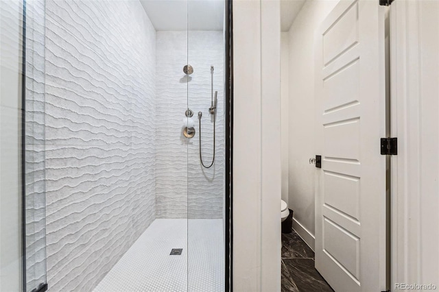 bathroom with a shower with shower door and toilet