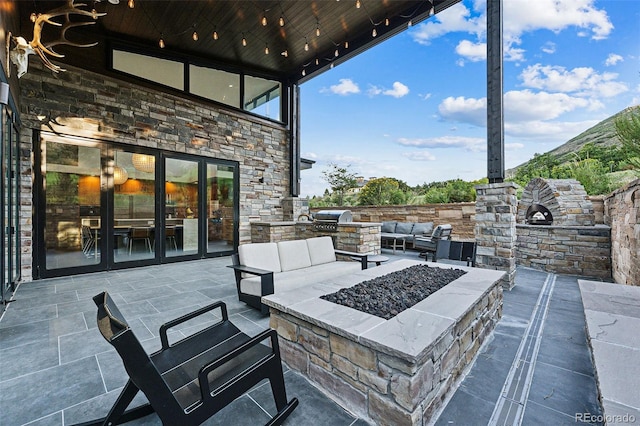 view of patio featuring area for grilling and an outdoor living space with a fire pit