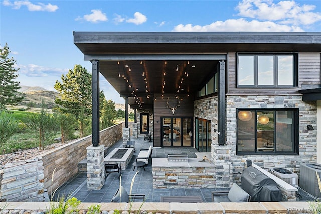 view of patio with a mountain view, central AC, and an outdoor fire pit