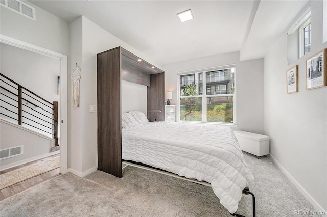 carpeted bedroom with baseboards, multiple windows, and visible vents