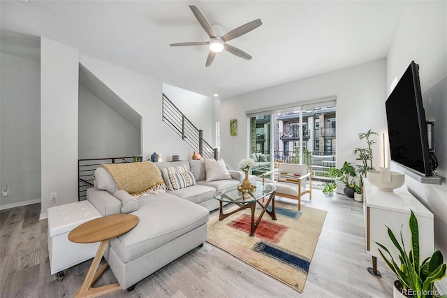 living area with a ceiling fan and wood finished floors