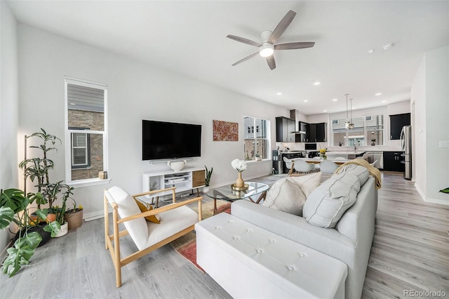 living room with recessed lighting, ceiling fan, baseboards, and light wood finished floors