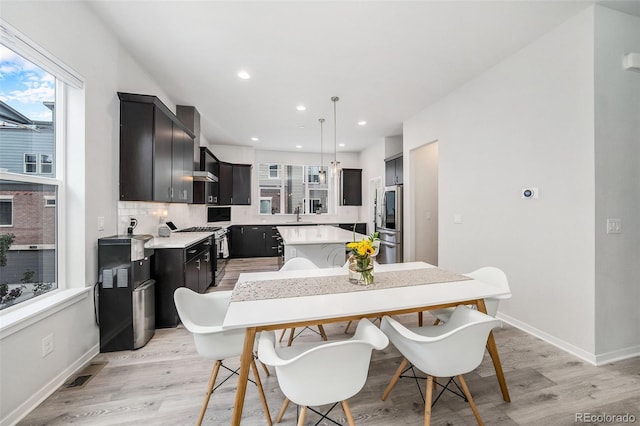 dining room with light wood-style floors, baseboards, recessed lighting, and visible vents