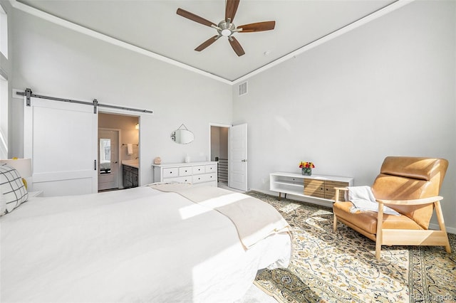 bedroom featuring crown molding, visible vents, ensuite bathroom, ceiling fan, and a barn door