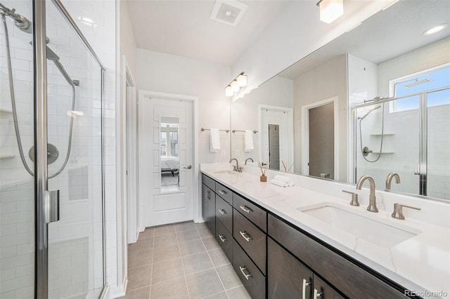 ensuite bathroom with a sink, tile patterned floors, a stall shower, and double vanity