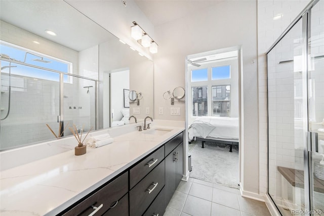 ensuite bathroom featuring vanity, a stall shower, tile patterned floors, and a wealth of natural light
