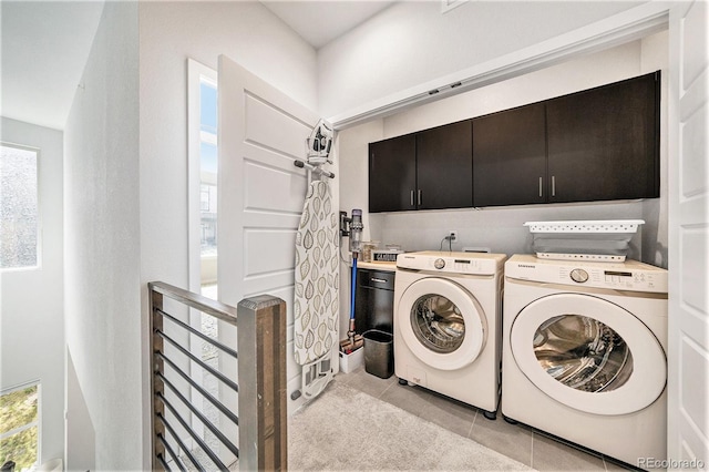 laundry room with cabinet space, plenty of natural light, light tile patterned floors, and washer and dryer