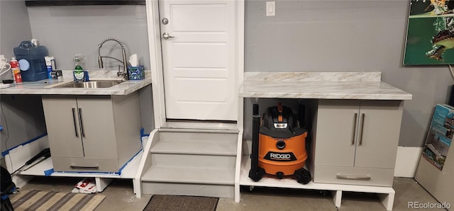 miscellaneous room with concrete floors and a sink