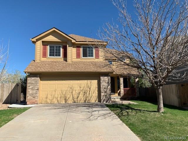 front facade with a garage and a front lawn