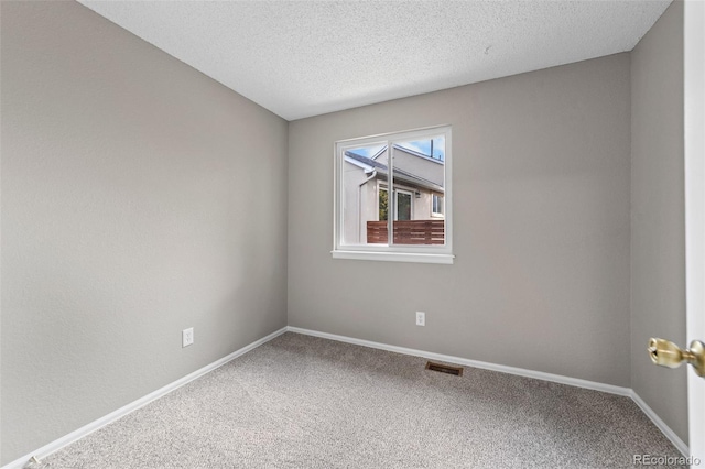 unfurnished room featuring carpet flooring and a textured ceiling