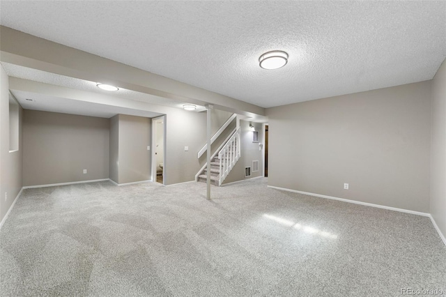 basement featuring a textured ceiling and carpet flooring