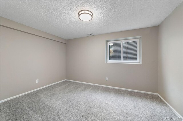 carpeted spare room featuring a textured ceiling