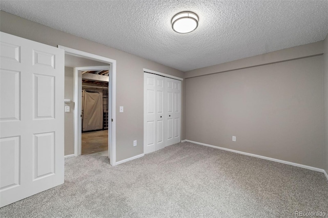 unfurnished bedroom with a closet, a textured ceiling, and light carpet