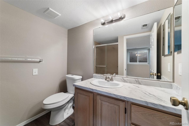 bathroom featuring toilet, an enclosed shower, vanity, and hardwood / wood-style flooring