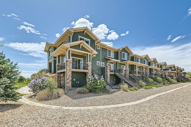 exterior space featuring a residential view, stairs, and stone siding