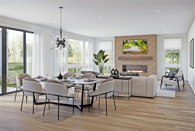 dining room featuring light wood-style flooring, plenty of natural light, a brick fireplace, a chandelier, and recessed lighting
