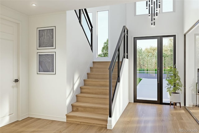 foyer with stairs, light wood-type flooring, and baseboards