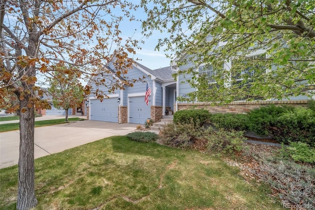 view of front facade featuring a garage, concrete driveway, a front yard, and brick siding
