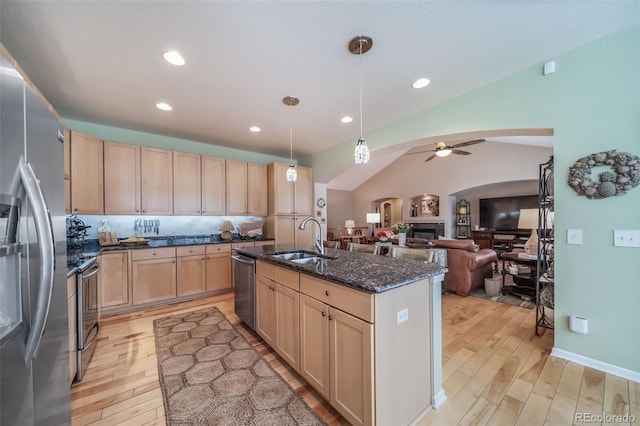 kitchen with light brown cabinetry, stainless steel appliances, a sink, and light wood-style floors