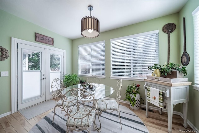 dining room with plenty of natural light, french doors, and light wood-style floors