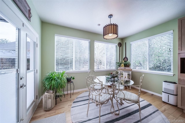 dining space with light wood-style floors and baseboards