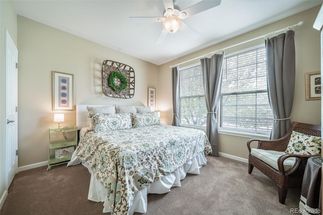 carpeted bedroom featuring baseboards, multiple windows, and ceiling fan