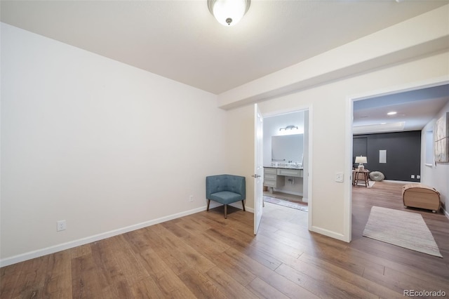 sitting room with baseboards and wood finished floors