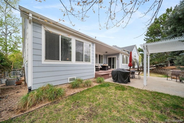 rear view of property featuring a lawn, a pergola, and a patio